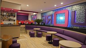 een restaurant met paarse banken en een bar bij Novo Coapa in Mexico-Stad