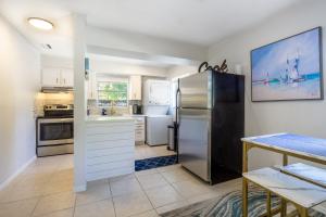 a kitchen with a stainless steel refrigerator and a table at Sparkling Oasis near Downtown ST Pete/Beach in St. Petersburg