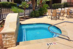 a small swimming pool in a patio with a table and chairs at River Zen CW C207 in New Braunfels