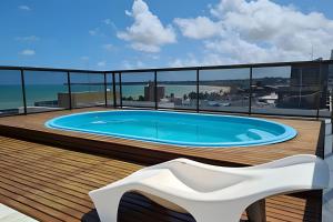 a swimming pool on a balcony with a white chair at Apto em Tambaú no coração turístico da cidade ! in João Pessoa