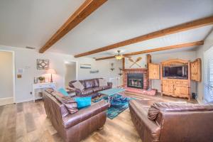 Elle comprend un salon doté d'un mobilier en cuir et d'une cheminée. dans l'établissement Hondo's River Haus RR 1300, à Canyon Lake