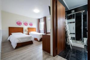 1 dormitorio con 2 camas y ducha a ras de suelo en Estalagem Pico D'Agua en Livramento