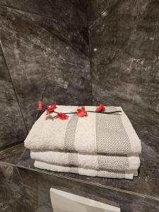 a table with a towel with red flowers on it at Kompfort Business Apartment in Wertheim