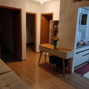 a living room with a table with flowers on it at Apartamento Aconchegante! in Uberaba