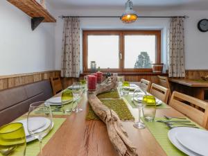 uma sala de jantar com uma mesa de madeira e copos de vinho em Seidlwinkel em Rauris