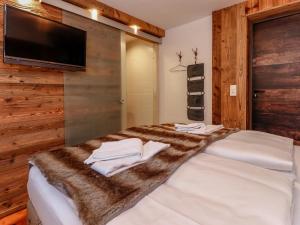um quarto com uma cama grande e um cobertor de pele falso em Seidlwinkel em Rauris