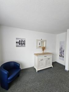 Zimmer mit einem blauen Stuhl und einem Schrank in der Unterkunft Kompfort Business Apartment in Wertheim