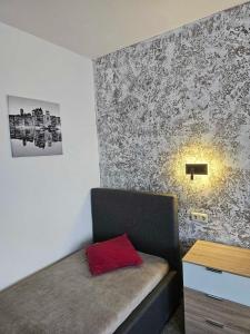 a bedroom with a bed with a red pillow on it at Kompfort Business Apartment in Wertheim