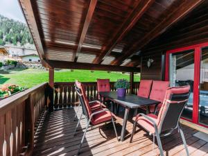 patio ze stołem i krzesłami na pokładzie w obiekcie Bernkogel Penthouse w mieście Rauris