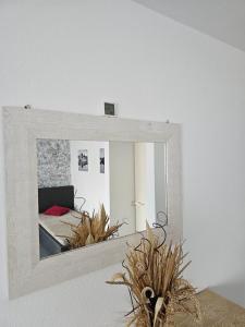 a mirror hanging on a wall in a bedroom at Kompfort Business Apartment in Wertheim