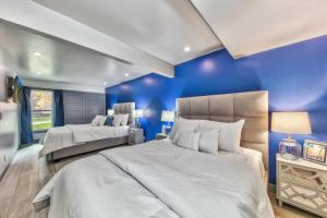 two beds in a bedroom with blue walls at Lakeland Village 468 Modern Marvel in South Lake Tahoe +30 photos
