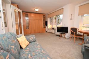 a living room with a couch and a television at Ferienwohnung-Ilka-WE-14 in Hohwacht