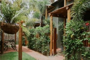 un jardin avec des plantes et une pergola en bois dans l'établissement Bangalô com Piscina Privativa, à Porto de Pedras