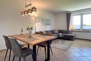 uma sala de estar com uma mesa e um sofá em Ferienwohnung-9-mit-Terrasse-Garten-Landhaus-Hubertus-Duhnen em Cuxhaven