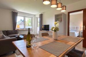 sala de estar con mesa de madera y copas de vino en Ferienwohnung-9-mit-Terrasse-Garten-Landhaus-Hubertus-Duhnen, en Cuxhaven