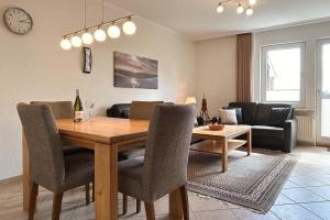sala de estar con mesa de comedor y sofá en Ferienwohnung-10-mit-Balkon-Garten-Landhaus-Hubertus-Duhnen, en Cuxhaven