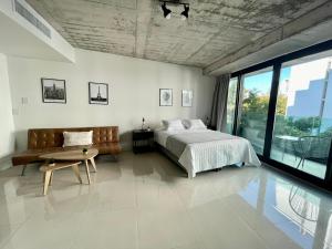 a bedroom with a bed and a couch and a table at Nova Stays - Estudio con balcón al Jardín Botánico de Palermo in Buenos Aires