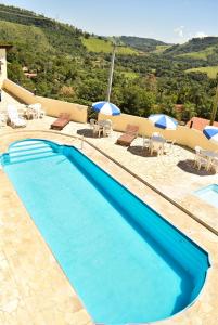 林多亞的住宿－普薩達考尼提旅館，一个带椅子和遮阳伞的蓝色游泳池