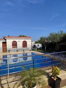una piscina frente a un edificio con un aro de baloncesto en Villa Naima, en Larache