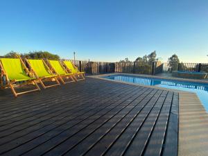 - une rangée de transats à côté de la piscine dans l'établissement Casa en Algarrobo, parcela en sector Mirasol, à Algarrobo