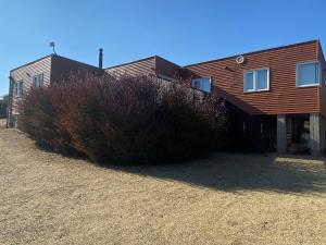 une maison avec une brousse devant elle dans l'établissement Casa en Algarrobo, parcela en sector Mirasol, à Algarrobo