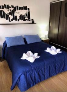 a blue bed with two white towels on it at Apartamento El Hornero in San Rafael