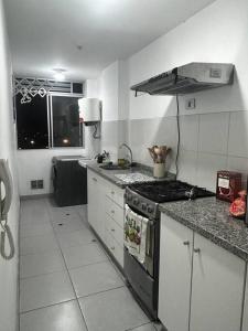 a kitchen with a stove and a counter top at Departamento familiar en el centro de Lima Perú in Lima