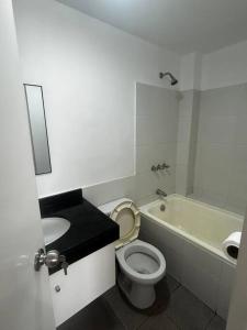 a bathroom with a toilet and a sink and a tub at Departamento familiar en el centro de Lima Perú in Lima