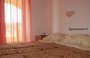 a bed in a room with a window and a bedspread at Apartments with WiFi Lopar, Rab - 14804 in Lopar