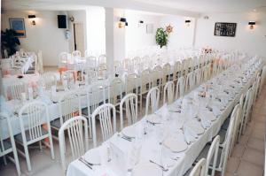 eine Reihe von Tischen mit weißen Stühlen in einem Zimmer in der Unterkunft Plaça Vella in Sant Carles de la Ràpita
