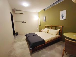 Un dormitorio con una cama y una mesa. en The Cottage Stay formerly Sunset Homestay 2, en Kuching