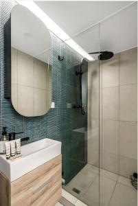 bagno con doccia, lavandino e specchio di Cosy Retreat in Bondi Junction -1BR Gem a Sydney