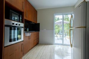 a kitchen with wooden cabinets and a sliding glass door at Estalagem Pico D'Agua in Livramento