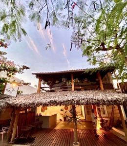 a house with a straw roof and a deck at Pousada Nativa Jeri in Jericoacoara