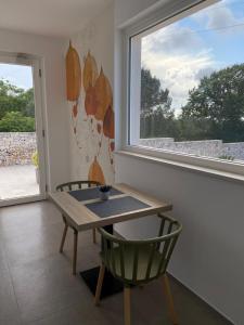 a table and a chair in a room with a window at Porta dell'est in Noci