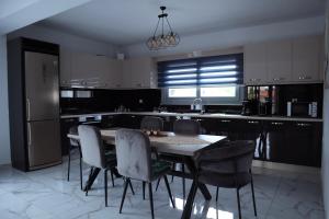a kitchen with a table and chairs and a refrigerator at Newly Built Villa, Chora Pythagoreio in Pythagoreio