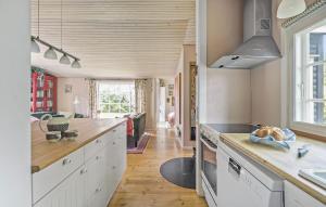 a kitchen with white cabinets and a counter top at Three-Bedroom Holiday Home In Hornbak in Hornbæk