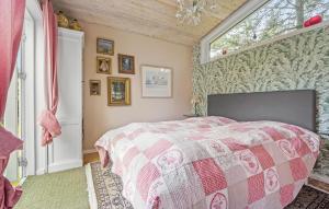 a bedroom with a pink and white bed and a window at Three-Bedroom Holiday Home In Hornbak in Hornbæk +10 photos
