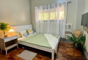 a small bedroom with a bed and a window at Waves 'n Sweet Homestay in San Juan