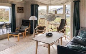 BjerregårdにあるCozy Home In Hvide Sande With Wifiのリビングルーム(ソファ、椅子、テーブル付)