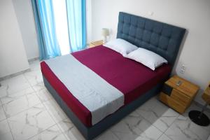 um quarto com uma cama grande com lençóis roxos e brancos em Νεόκτιστη βίλα, Χώρα Πυθαγορείου em Pythagoreio