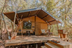 een tent met een tafel en stoelen op een houten terras bij Rodavento Boutique Hotel & Spa in Valle de Bravo