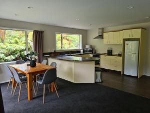 a kitchen with a table and a table and chairs at Rainforest Retreat in Franz Josef