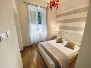 a bedroom with a bed and a window and a chandelier at LEO'S HOME in La Spezia