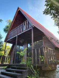 uma pequena cabana com um telhado vermelho e algumas escadas em Eco Aldea kinich Ahau em Xpujil