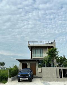 a blue car parked in front of a house at Villa AZJA PD in Port Dickson