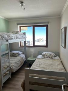 two bunk beds in a room with a window at Valle Nevado Apartamento Ski In Out in Valle Nevado +28 photos