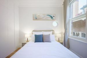 1 dormitorio con cama blanca y almohadas azules en Cosy Federation Apartment Kirribilli 4 Bedroom en Sídney