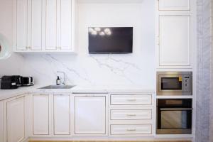 a white kitchen with a sink and a microwave at Cosy Federation Apartment Kirribilli 4 Bedroom in Sydney