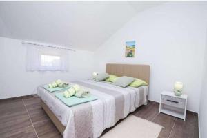 a bedroom with a bed with two pillows on it at Apartments with parking space Bonic, Losinj - 23056 in Veli Lošinj